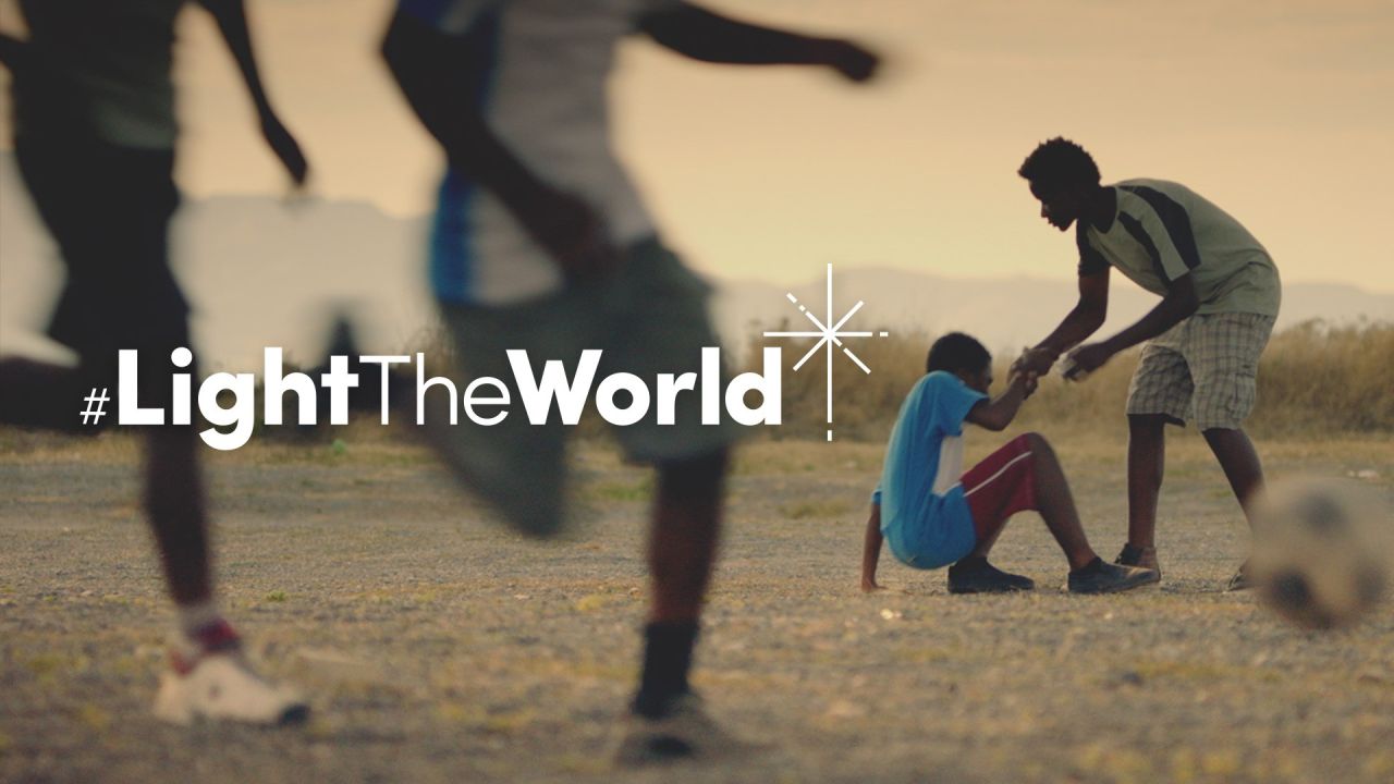 Дечак помаже другом дечаку да устане након што је пао на фудбалу у видеу Обасјајте свет